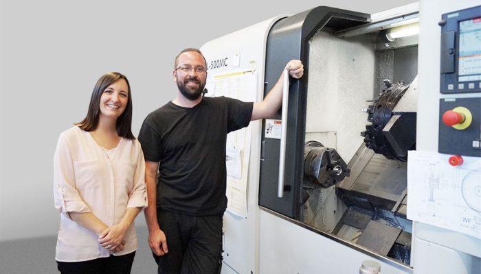 Verkäuferin und Kunde vor einem großen Bearbeitungszentrum