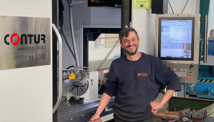 Glücklicher Kunde vor einem Bearbeitungszentrum