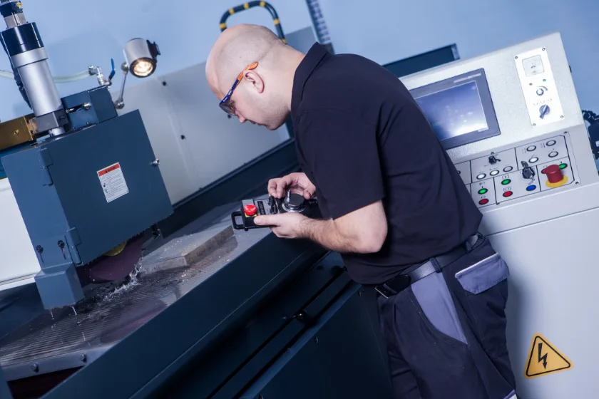 Techniker bedient Flaschleifmaschine